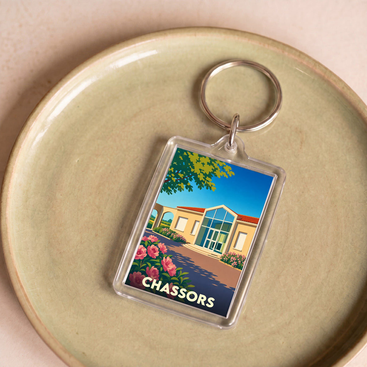 Porte-clés souvenir de la ville de Chassors avec une illustration stylisée.