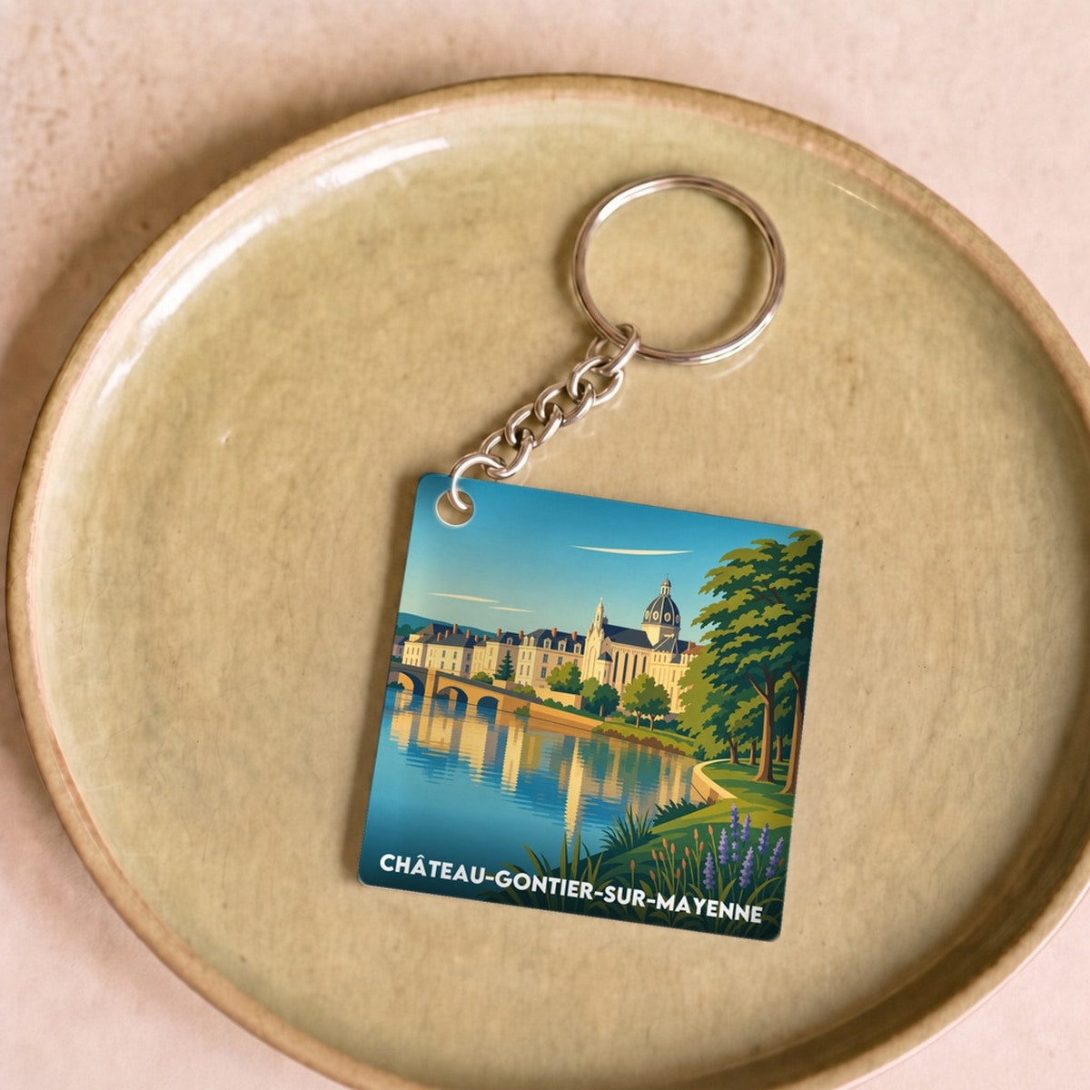 Porte-clés souvenir de la ville de Château-Gontier-sur-Mayenne avec une illustration stylisée.