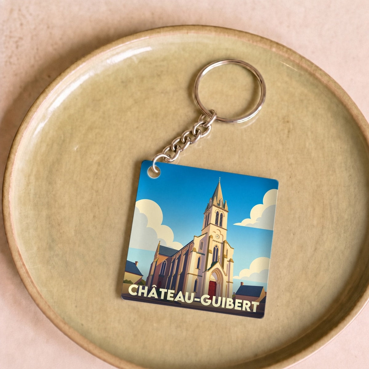 Porte-clés souvenir de la ville de Château-Guibert avec une illustration stylisée de son église.
