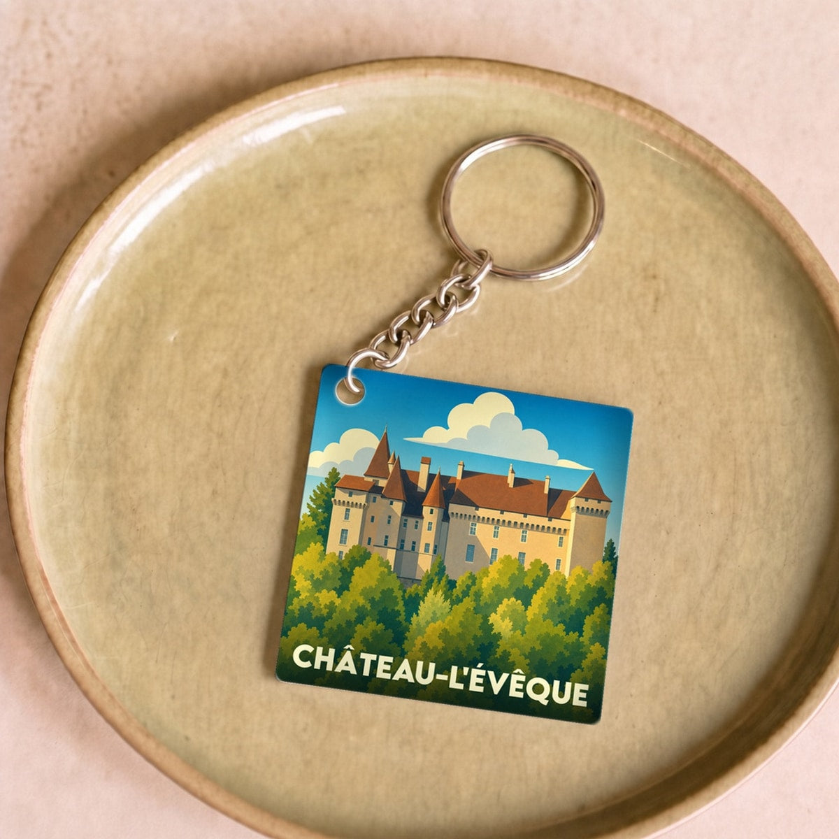Porte-clés souvenir de la ville de Château-l'Évêque avec une illustration stylisée de son château.