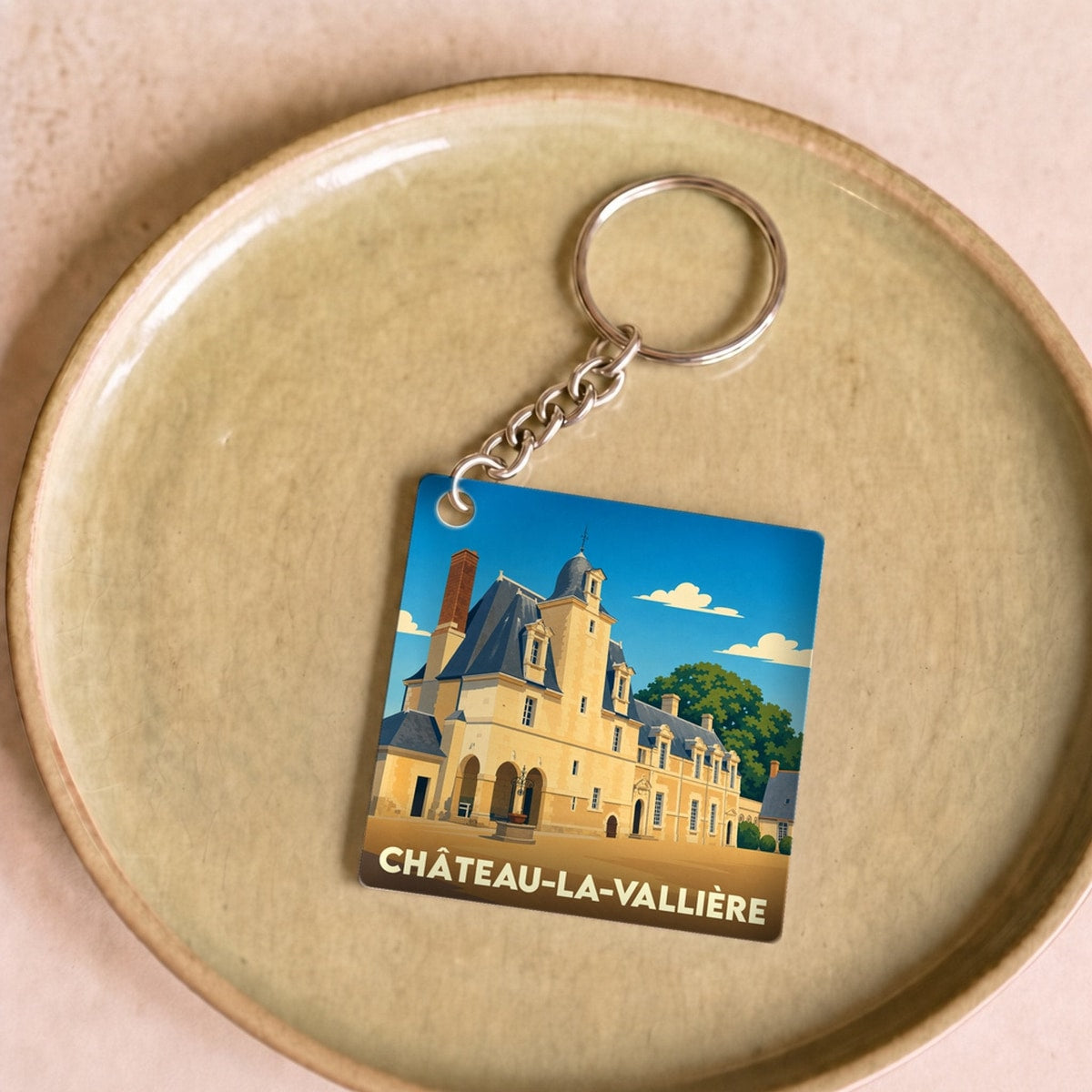 Porte-clés souvenir de la ville de Château-la-Vallière avec une illustration stylisée de son patrimoine.