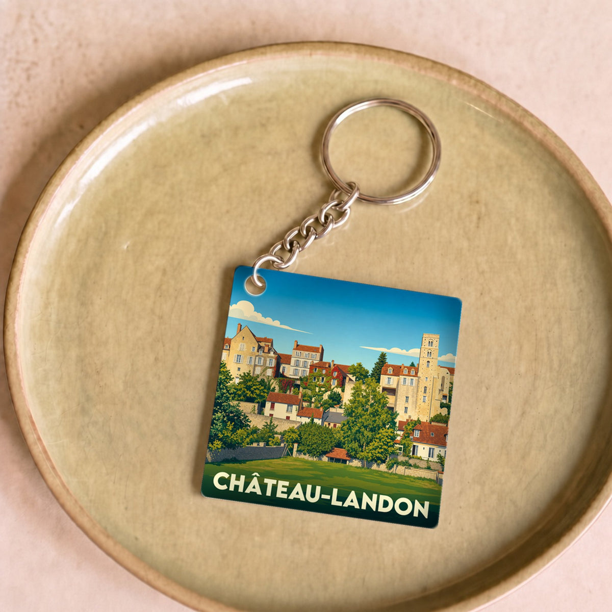 Porte-clés souvenir de la ville de Château-Landon avec une illustration stylisée.