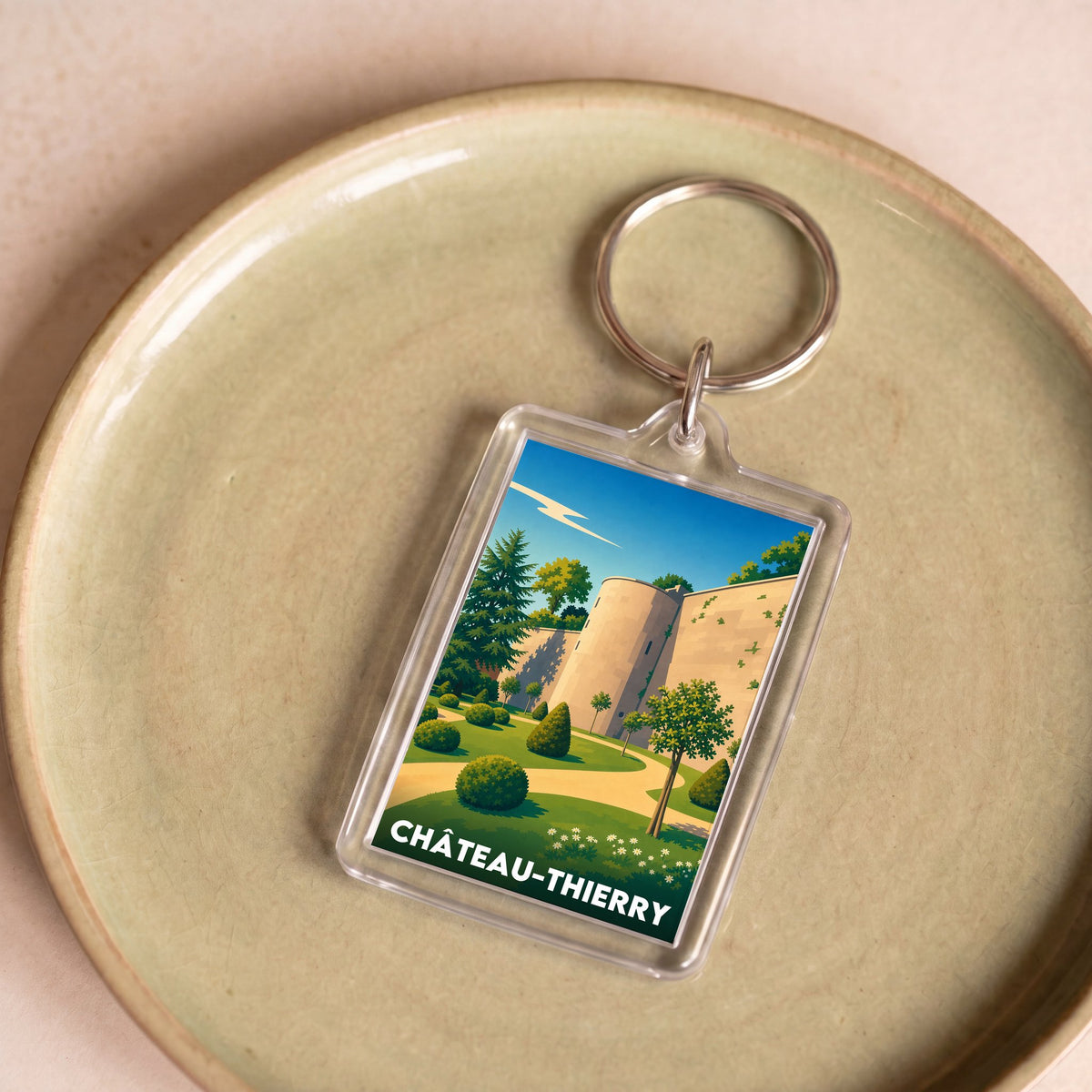 Porte-clés souvenir de la ville de Château-Thierry avec une illustration stylisée.