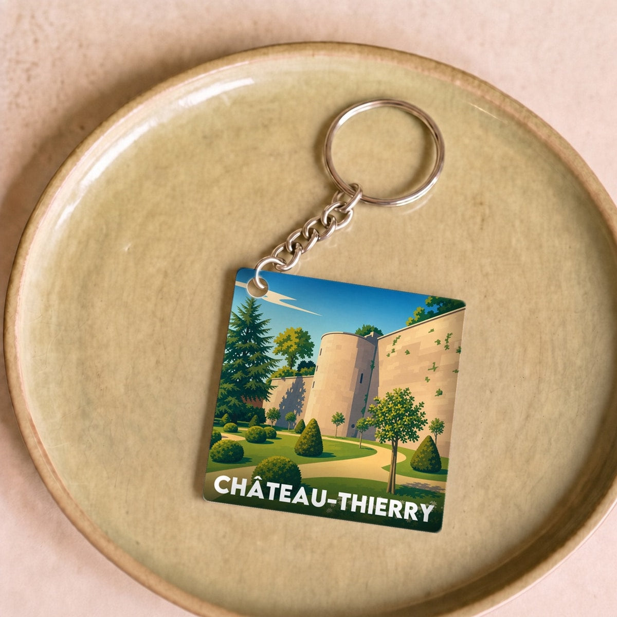 Porte-clés souvenir de la ville de Château-Thierry avec une illustration stylisée.