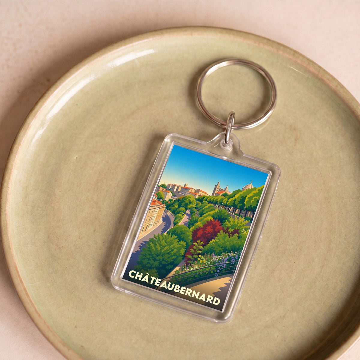 Porte-clés souvenir de la ville de Châteaubernard avec une illustration stylisée et colorée.