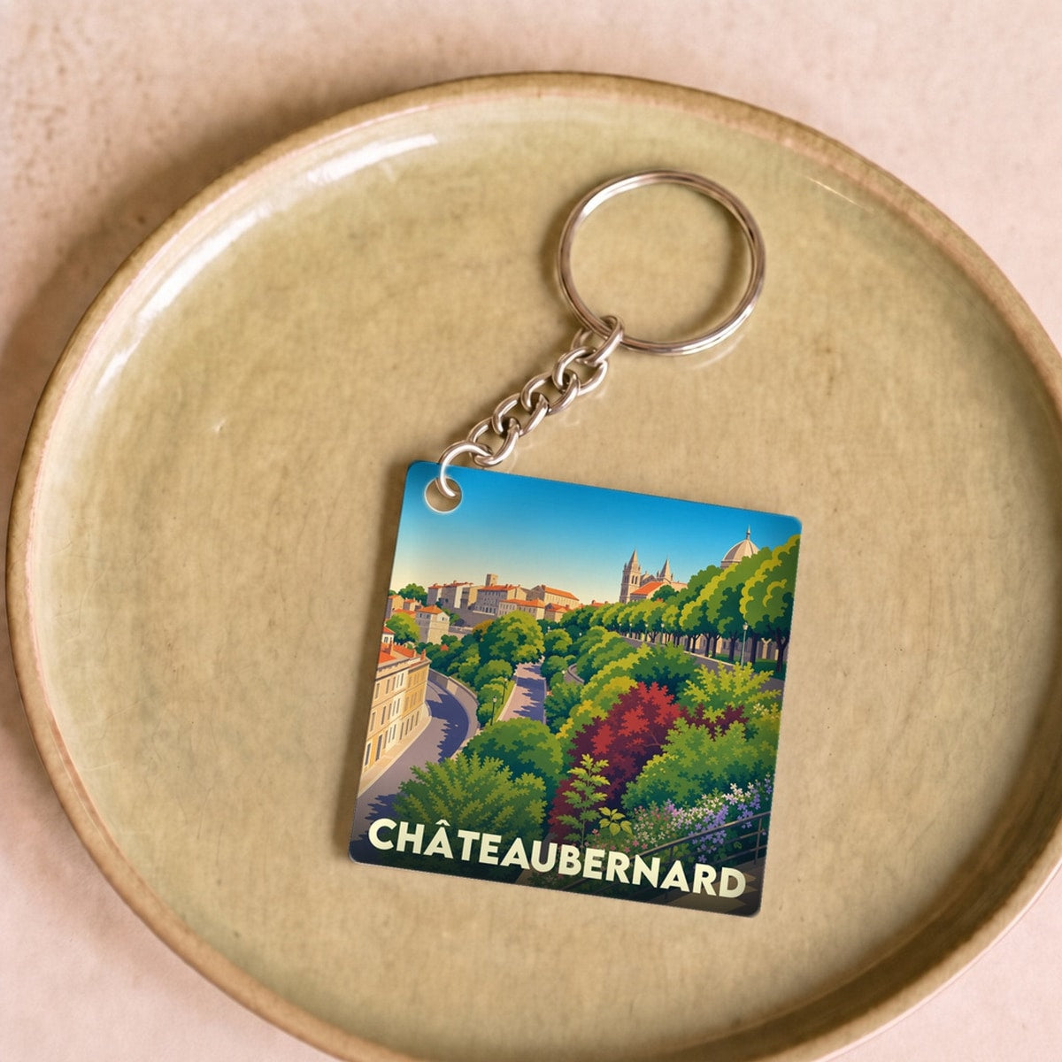 Porte-clés souvenir de la ville de Châteaubernard avec une illustration stylisée et colorée.
