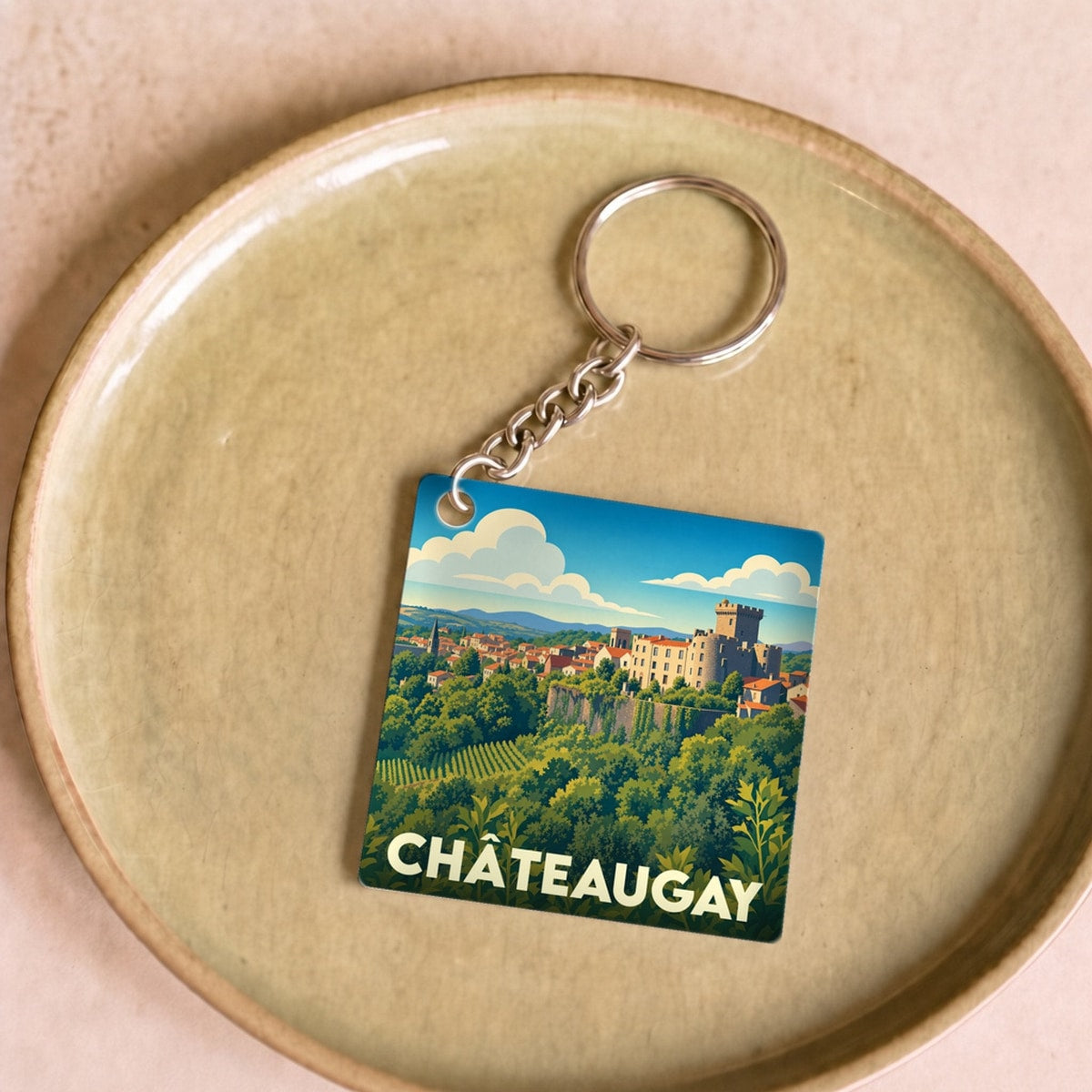 Porte-clés souvenir de la ville de Châteaugay avec une illustration stylisée.