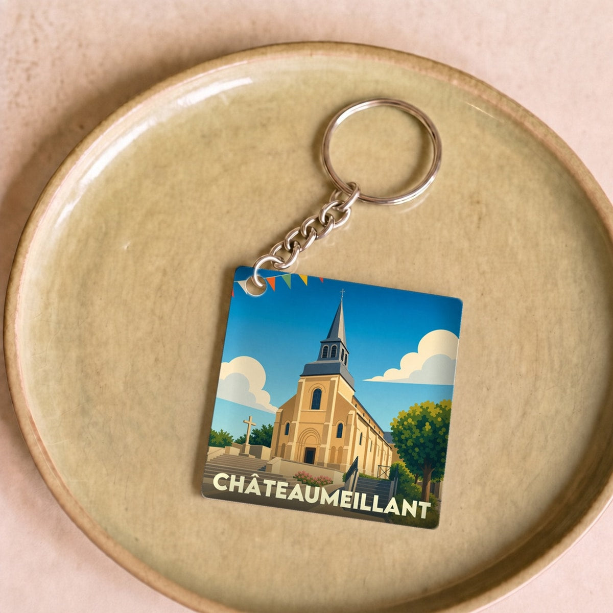Porte-clés souvenir de la ville de Châteaumeillant avec une illustration stylisée de son église.