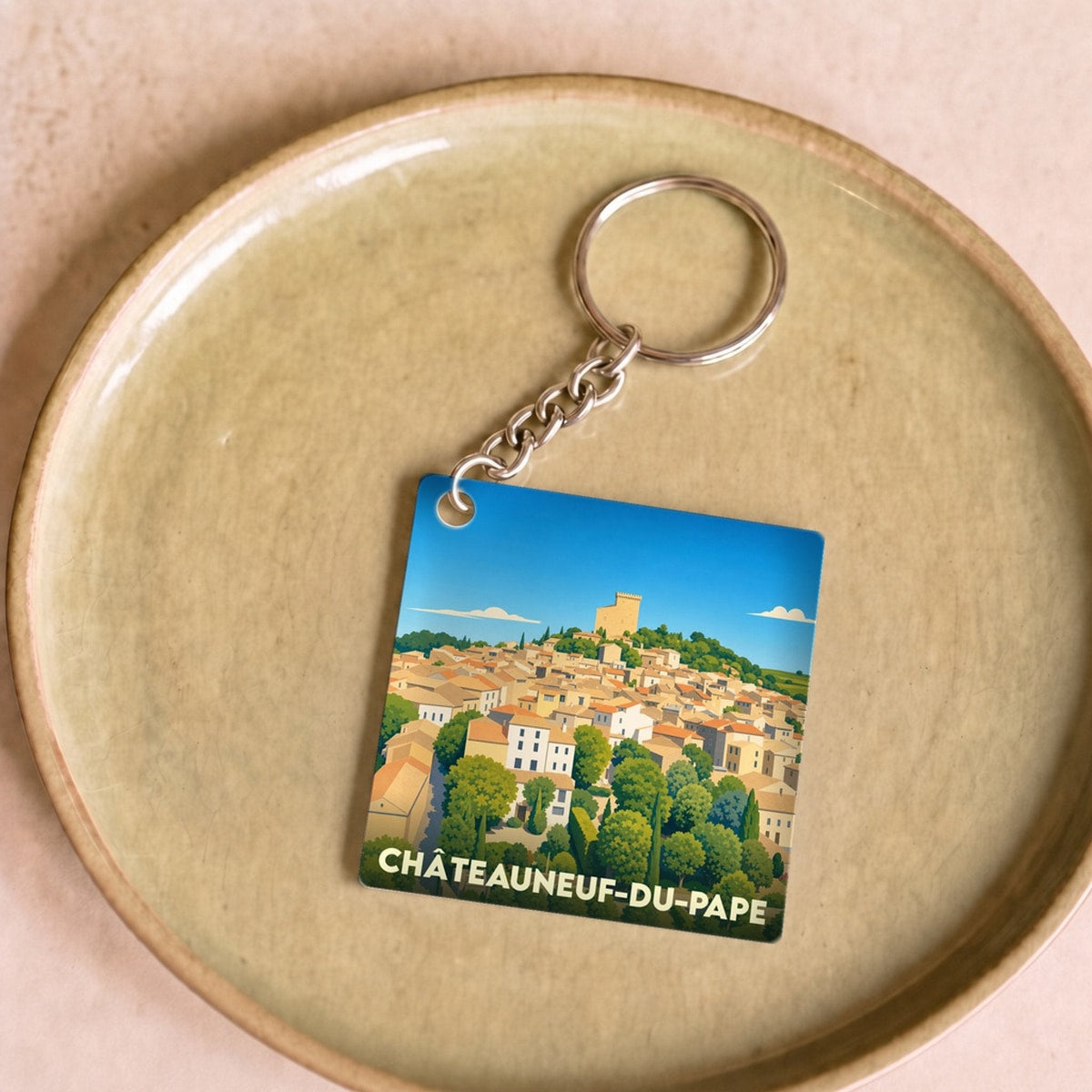 Porte-clés souvenir de Châteauneuf-du-Pape avec une illustration stylisée du village et de son château.