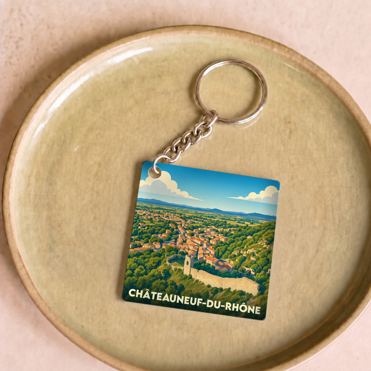 Porte-clés souvenir de la ville de Châteauneuf-du-Rhône avec une illustration stylisée.
