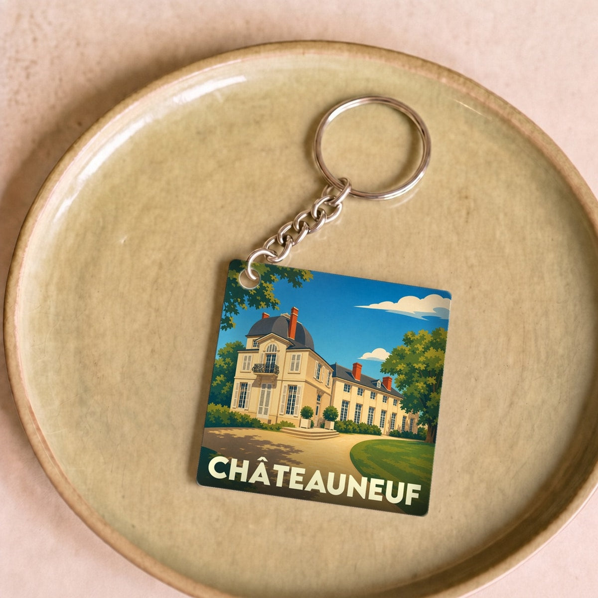 Porte-clés souvenir de la ville de Châteauneuf avec une illustration stylisée de son château.