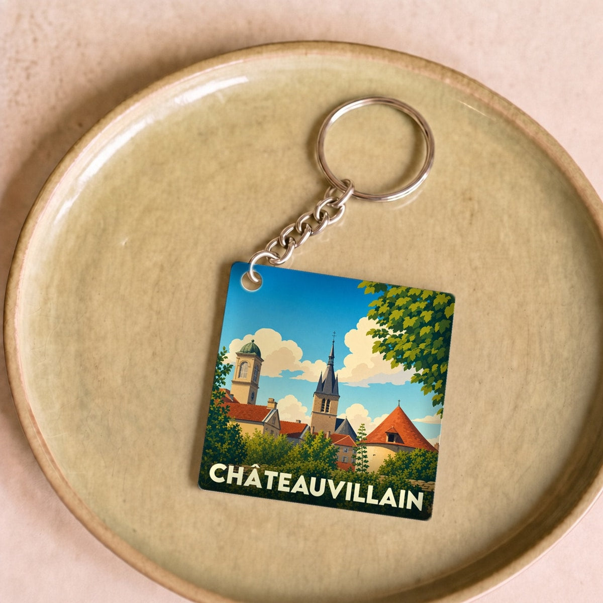 Porte-clés souvenir de la ville de Châteauvillain avec une illustration stylisée.