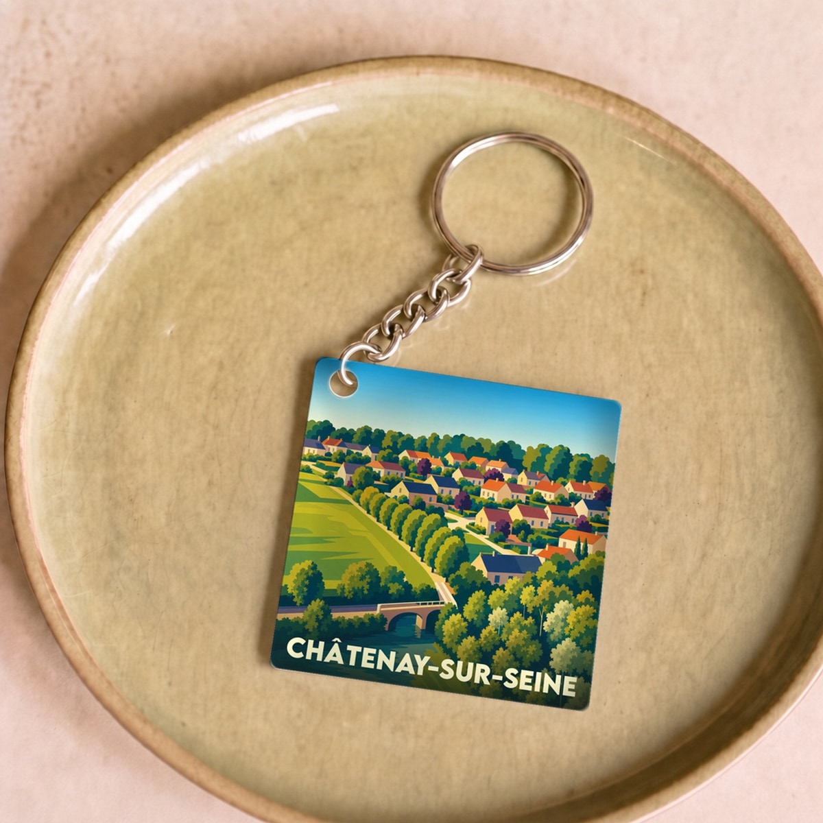 Porte-clés souvenir de la ville de Châtenay-sur-Seine avec une illustration stylisée.