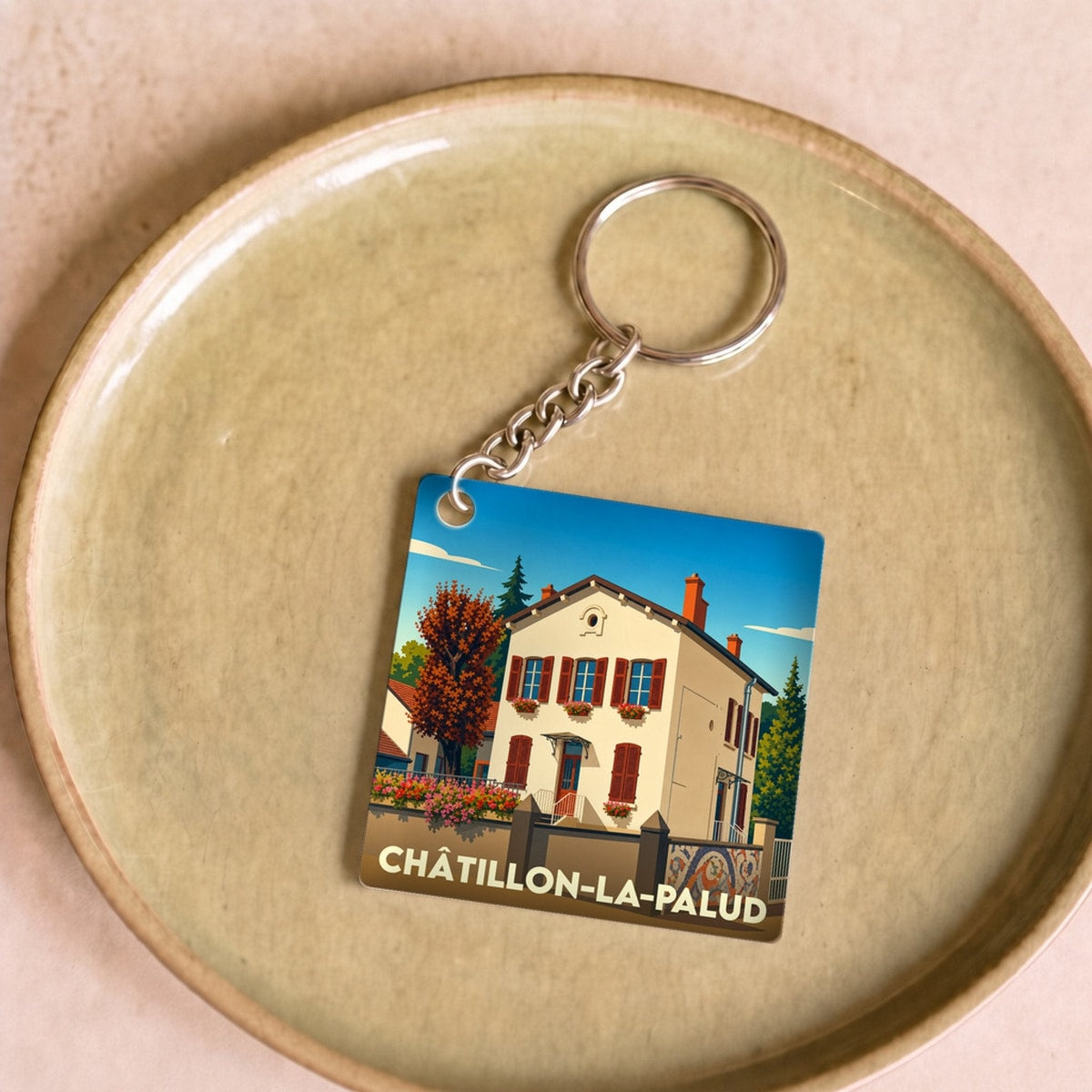 Porte-clés souvenir de la ville de Châtillon-la-Palud avec une illustration stylisée d'une maison traditionnelle.