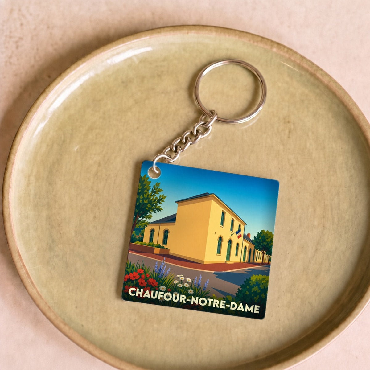 Porte-clés souvenir de la ville de Chaufour-Notre-Dame avec une illustration stylisée.