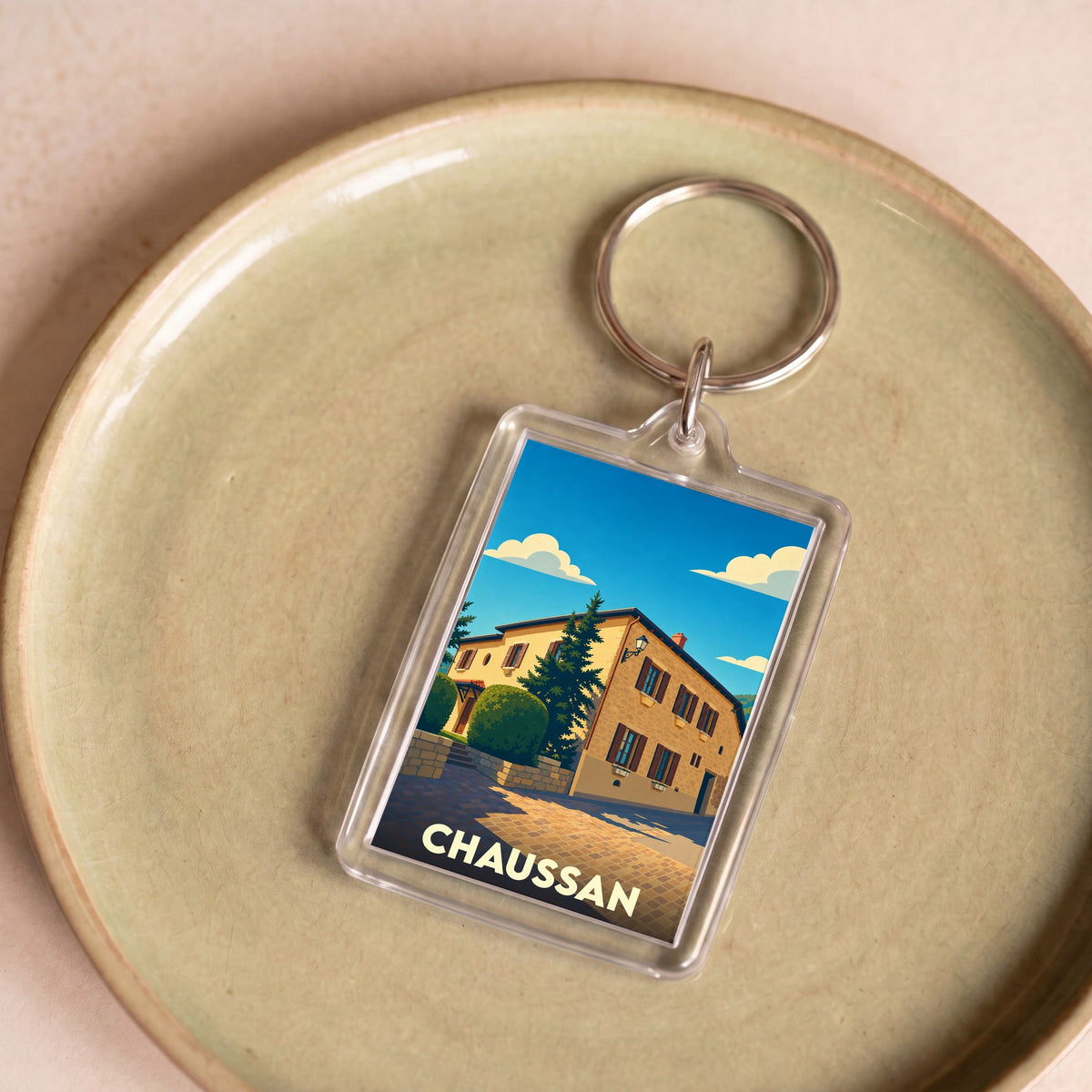 Porte-clés souvenir de la ville de Chaussan avec une illustration stylisée.