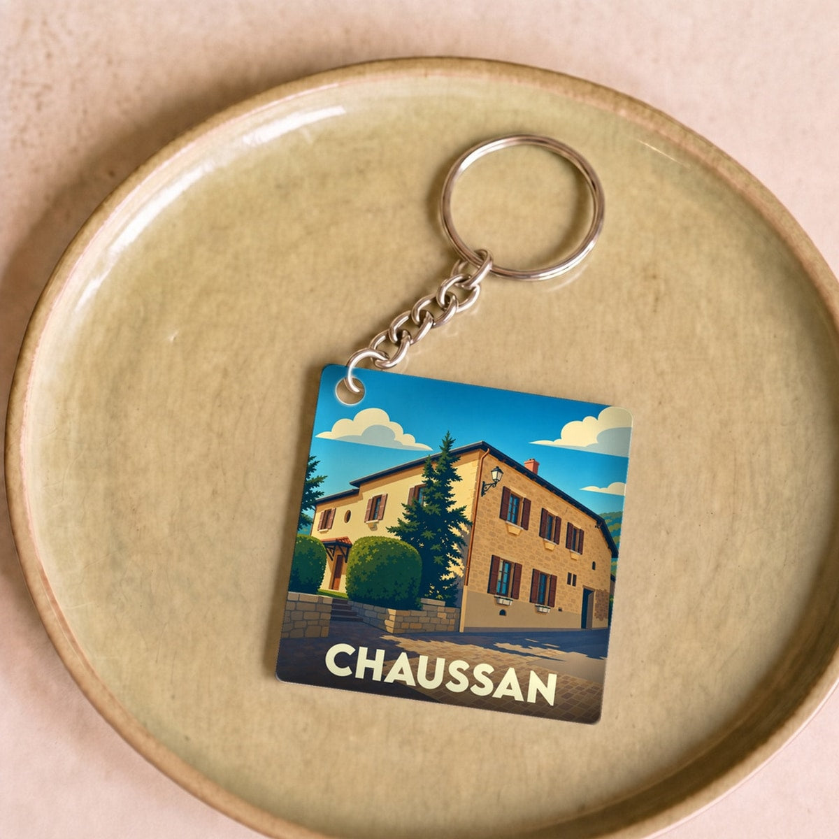Porte-clés souvenir de la ville de Chaussan avec une illustration stylisée.