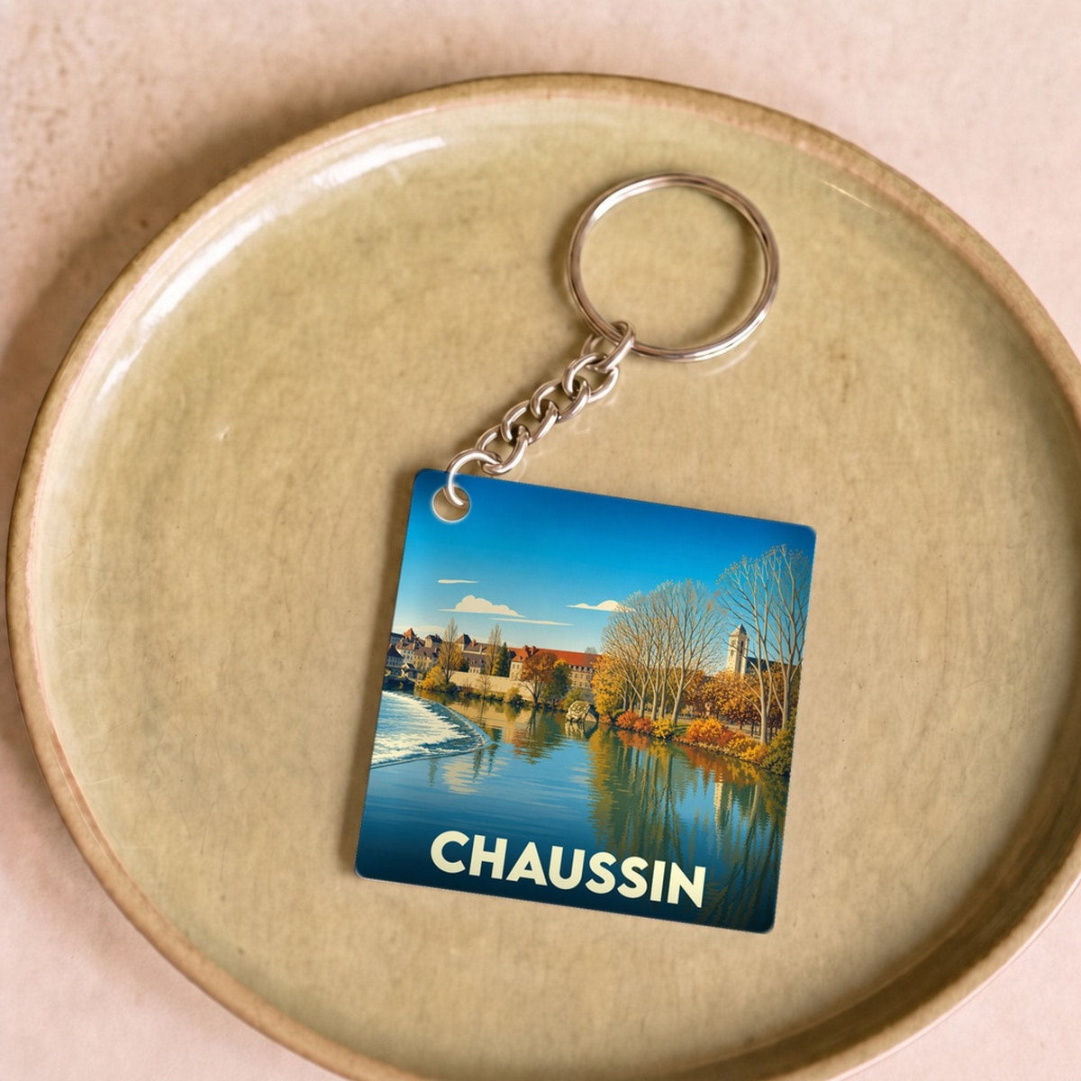 Porte-clés souvenir de la ville de Chaussin avec une illustration stylisée.