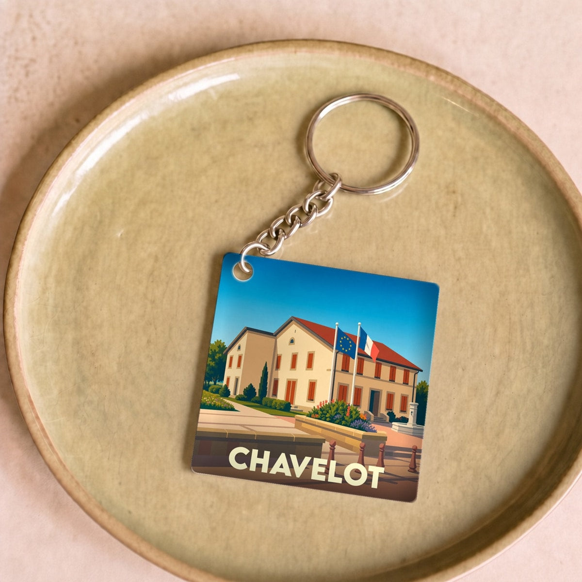 Porte-clés souvenir de la ville de Chavelot avec une illustration stylisée de sa mairie.