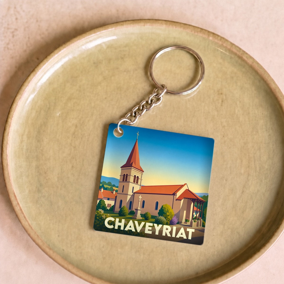 Porte-clés souvenir de la ville de Chaveyriat avec une illustration stylisée de son église.