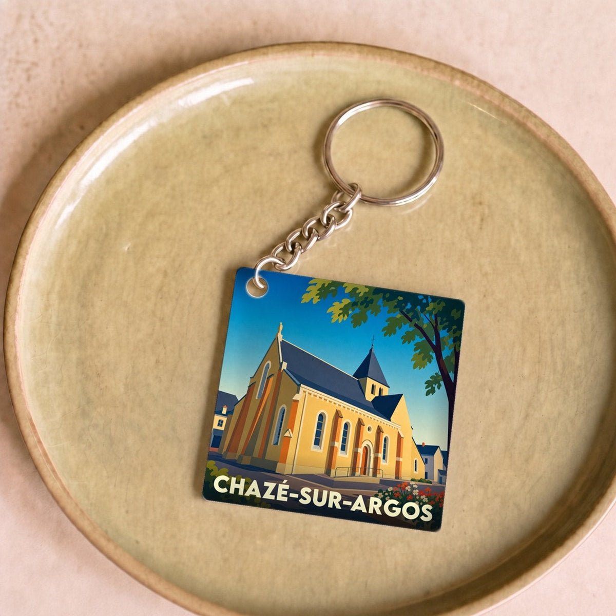 Porte-clés souvenir de la ville de Chazé-sur-Argos avec une illustration stylisée de son église.