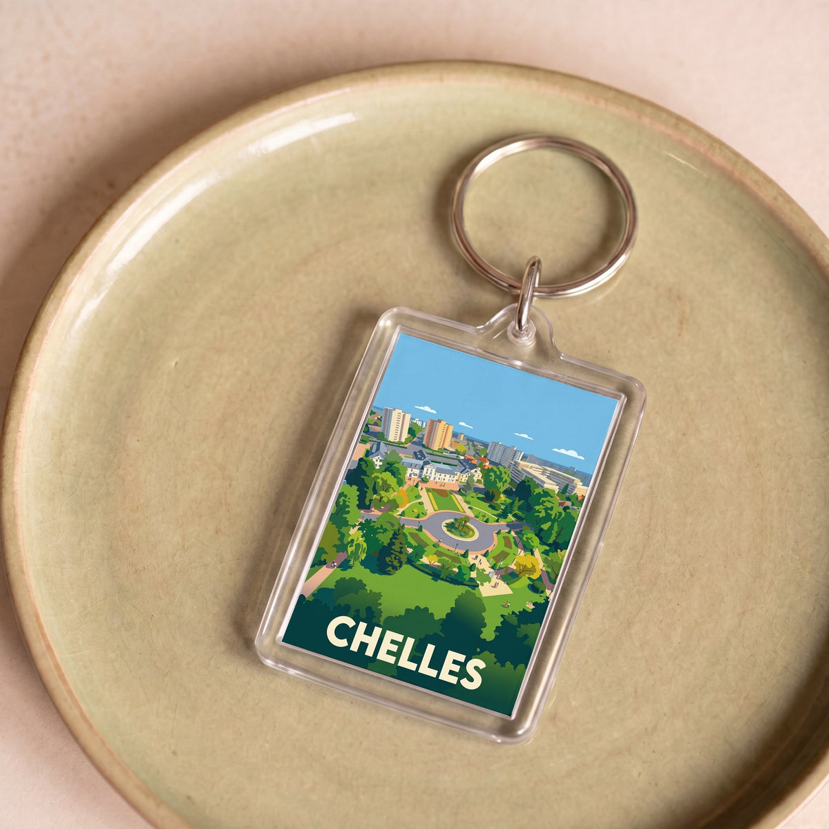 Porte-clés souvenir de la ville de Chelles avec une illustration stylisée.