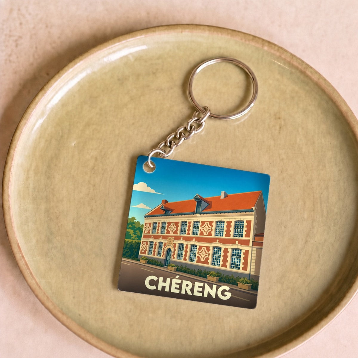 Porte-clés souvenir de la ville de Chéreng avec une illustration stylisée.