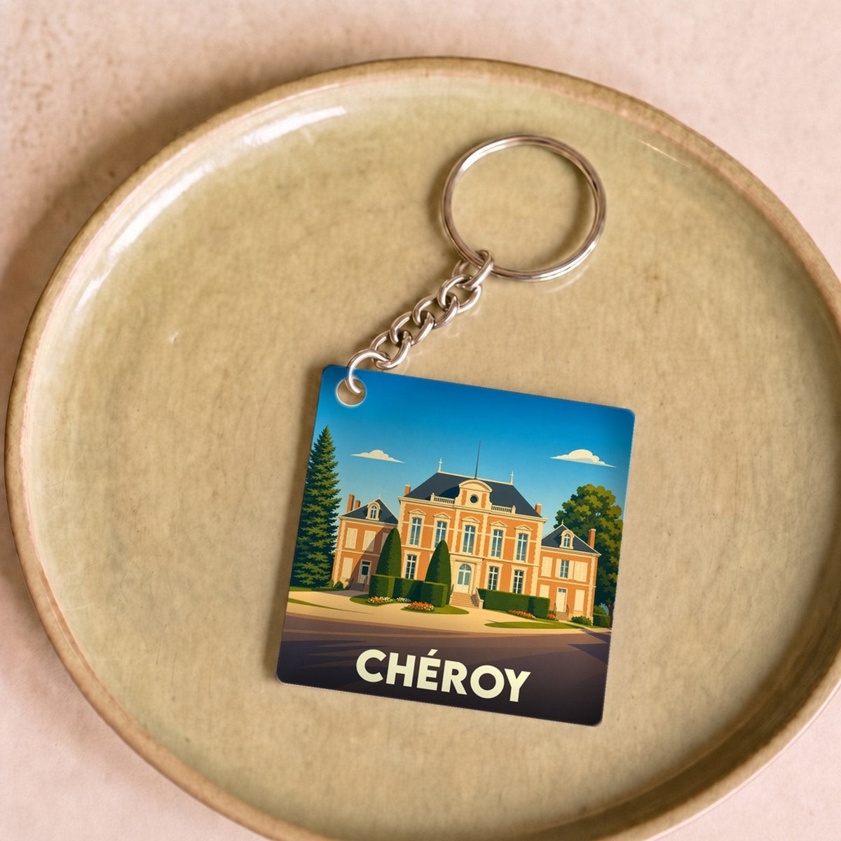 Porte-clés souvenir de la ville de Chéroy avec une illustration stylisée de son hôtel de ville.