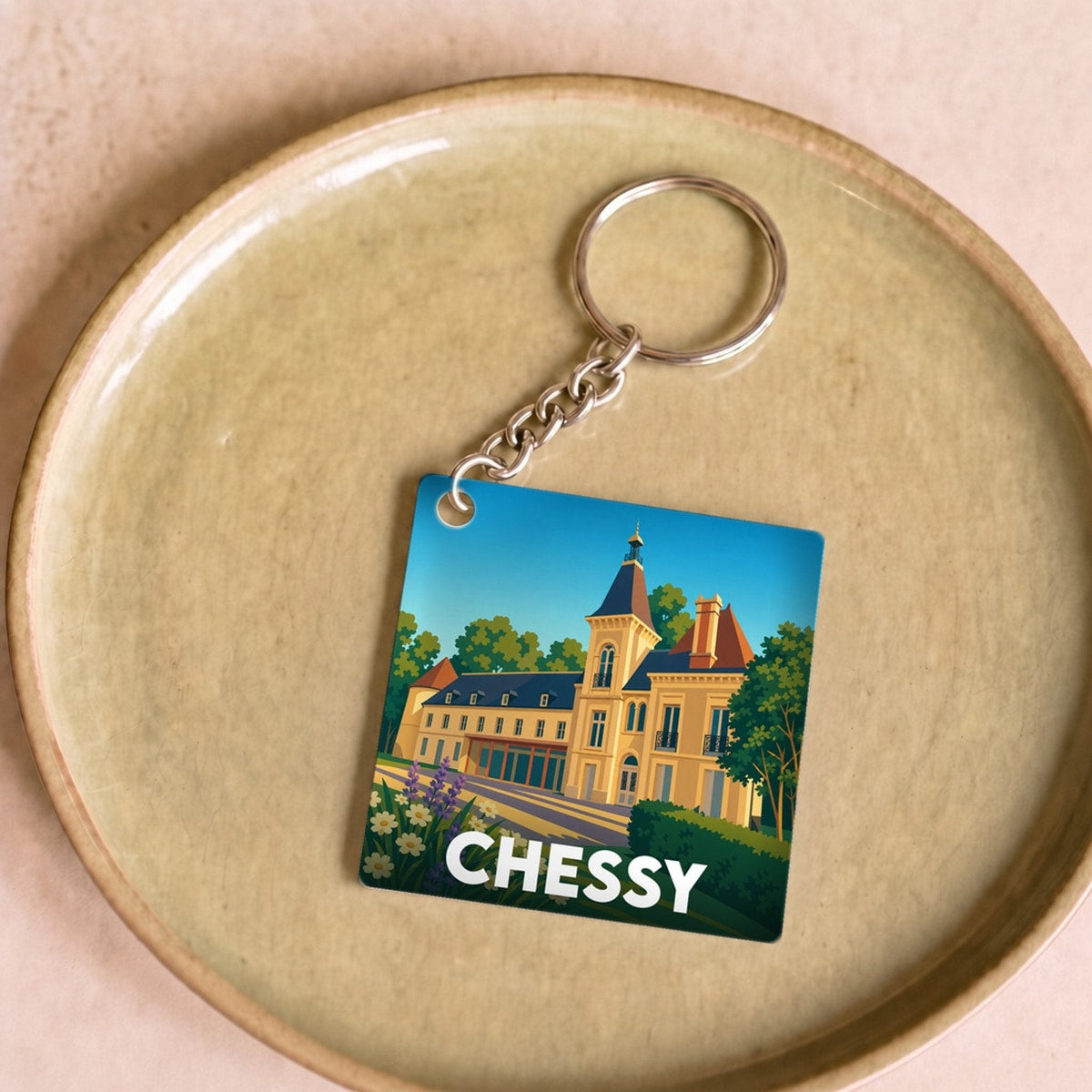 Porte-clés souvenir de la ville de Chessy avec une illustration stylisée de son château.