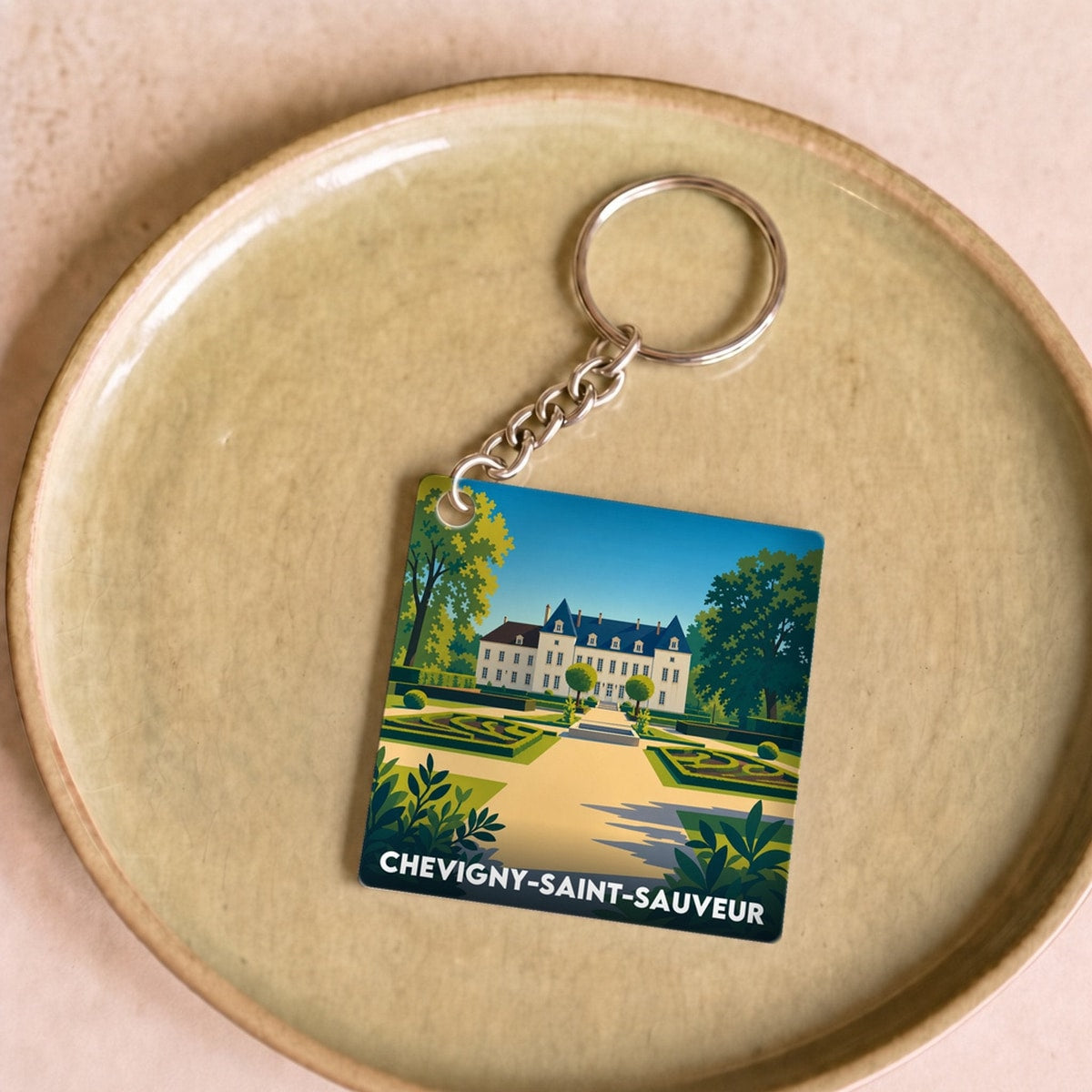 Porte-clés souvenir de la ville de Chevigny-Saint-Sauveur avec une illustration stylisée de son château.