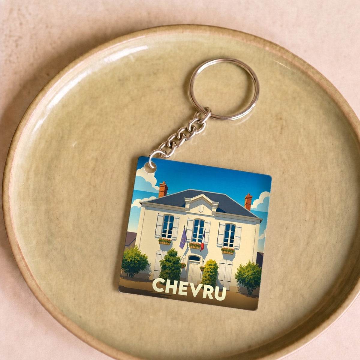 Porte-clés souvenir de la ville de Chevru avec une illustration stylisée.