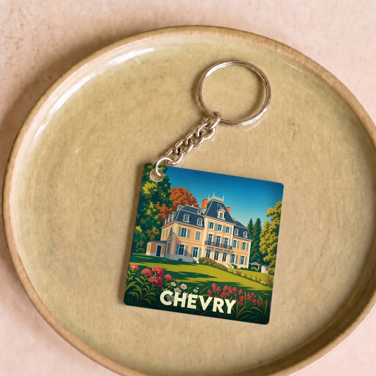 Porte-clés souvenir de la ville de Chevry avec une illustration stylisée d'un château.