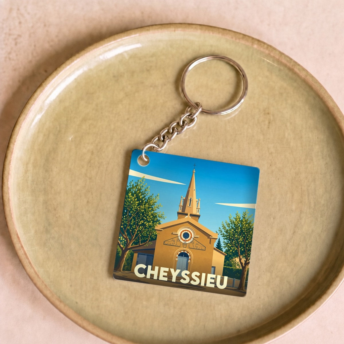 Porte-clés souvenir de la ville de Cheyssieu avec une illustration stylisée de son église.