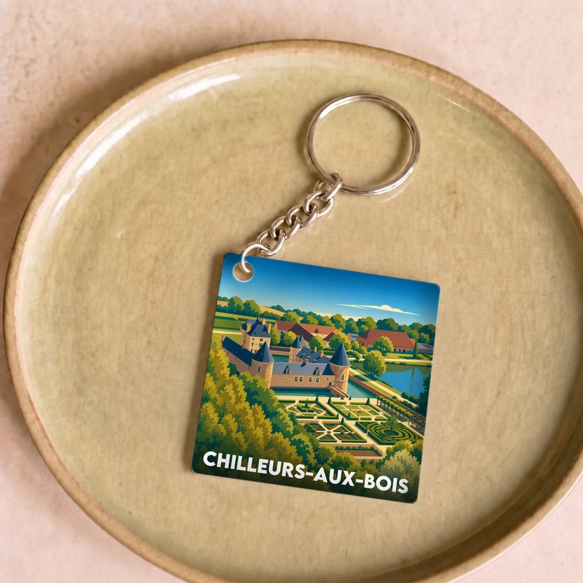 Porte-clés souvenir de la ville de Chilleurs-aux-Bois avec une illustration stylisée du paysage.