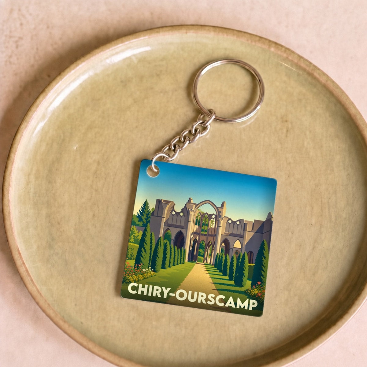 Porte-clés souvenir de la ville de Chiry-Ourscamp avec une illustration stylisée de son abbaye.