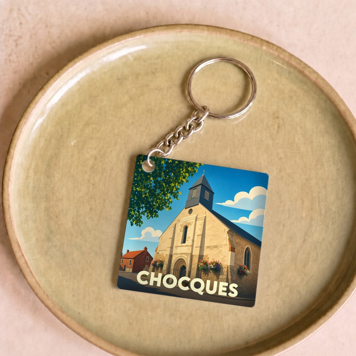 Porte-clés souvenir de la ville de Chocques avec une illustration stylisée de son église.