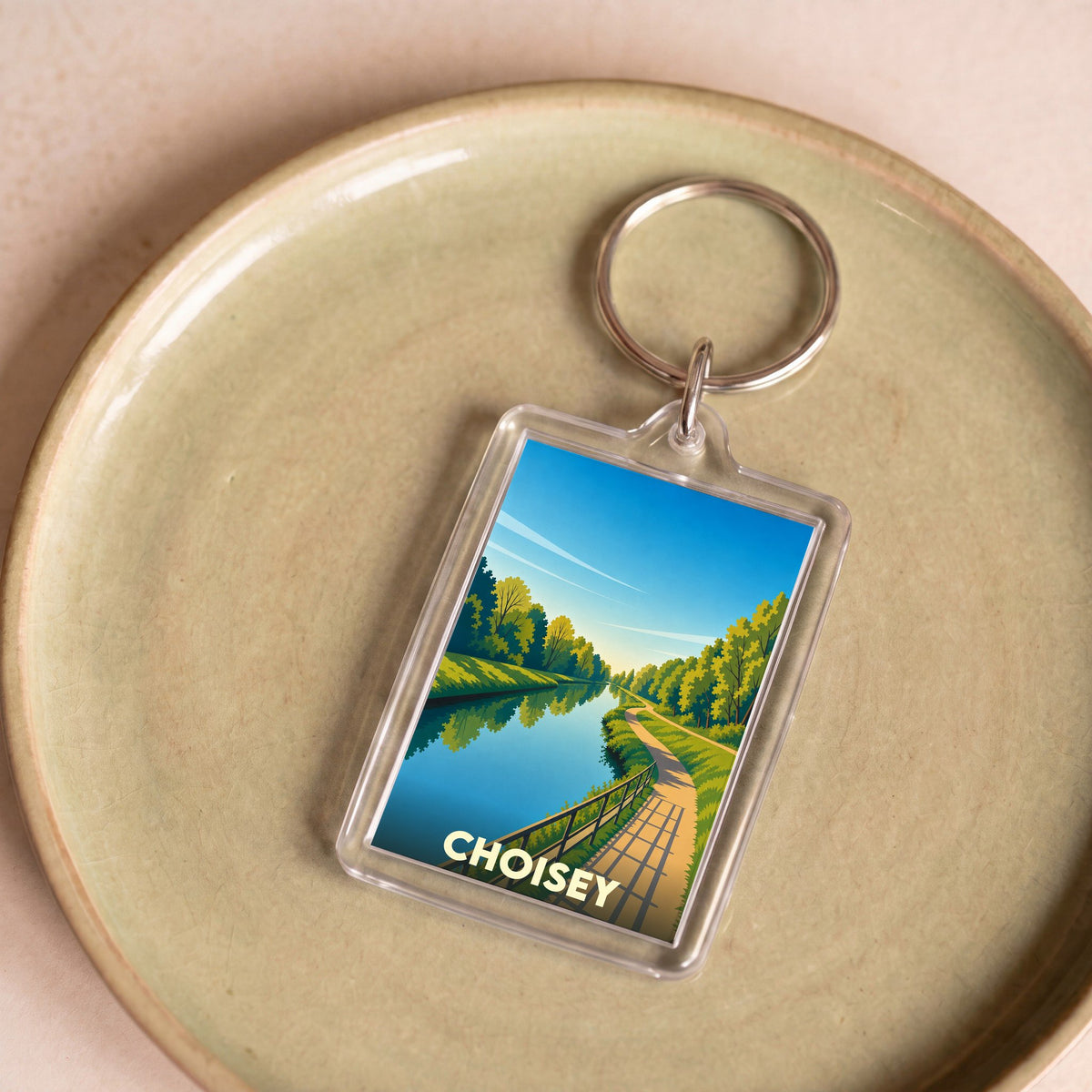 Porte-clés souvenir de la ville de Choisey avec une illustration stylisée d'un canal bordé d'arbres.