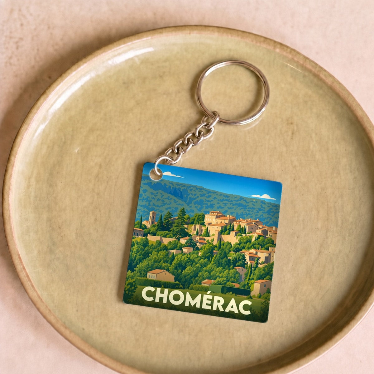 Porte-clés souvenir de la ville de Chomérac avec une illustration stylisée.