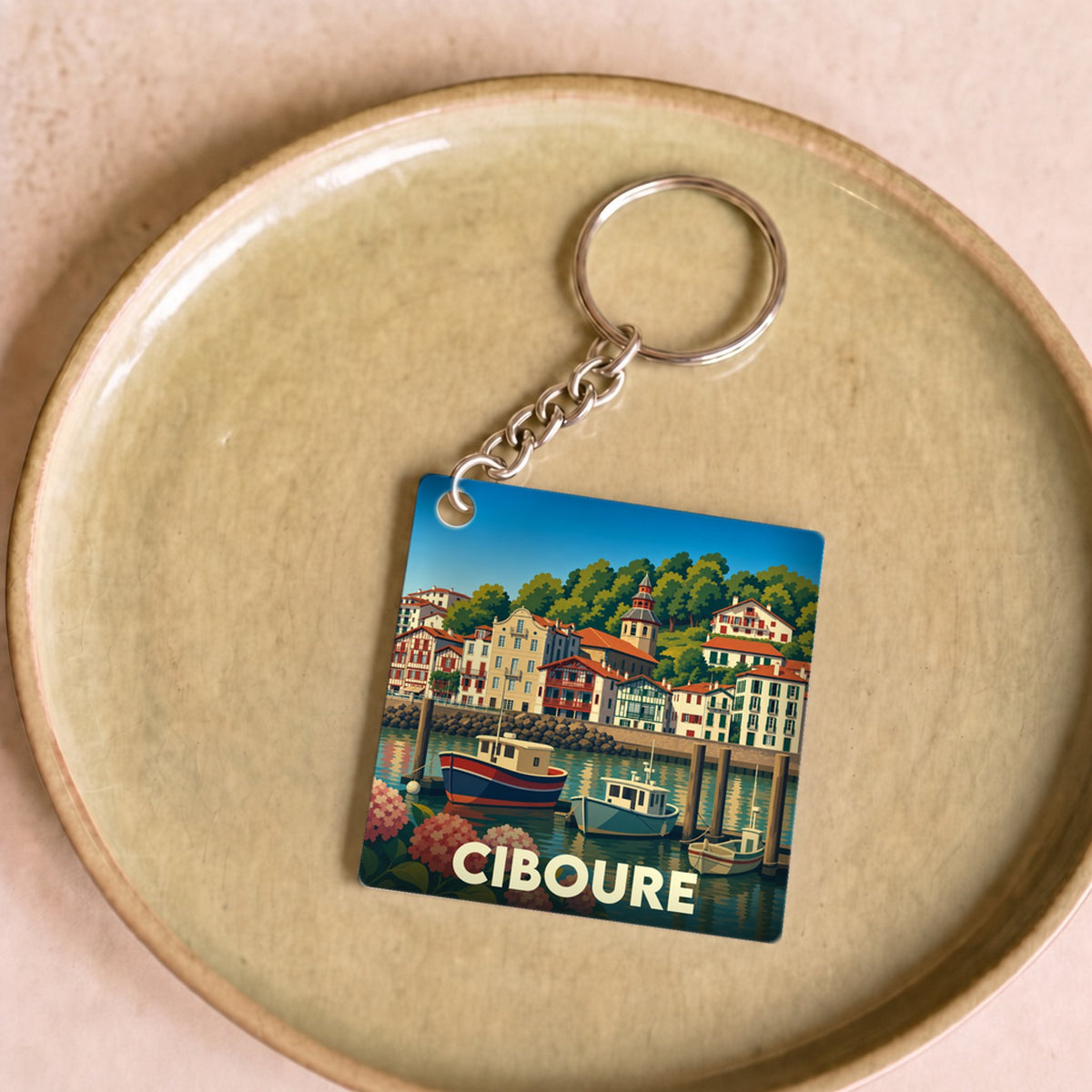 Porte-clés souvenir de la ville de Ciboure avec une illustration stylisée de son port.