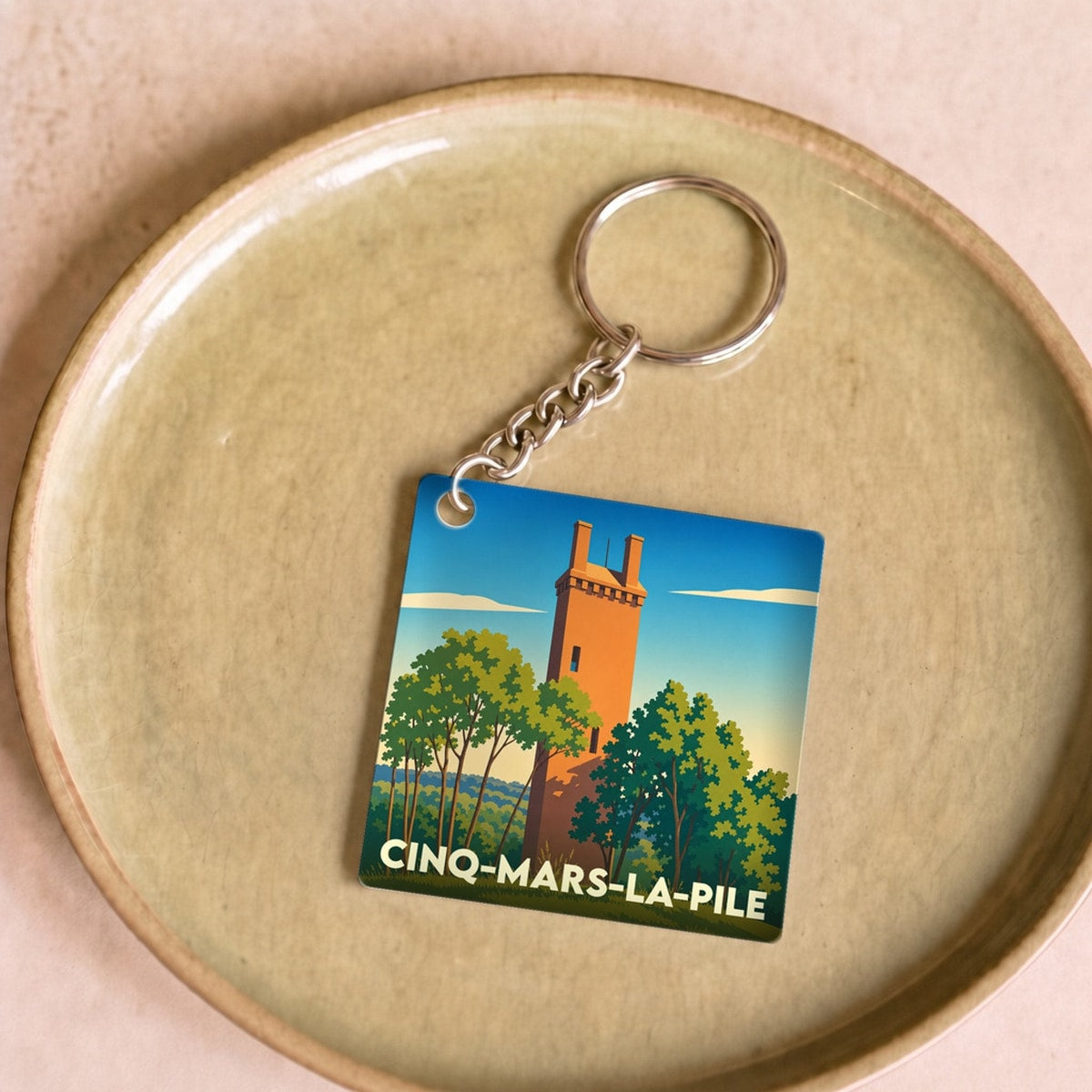 Porte-clés souvenir de la ville de Cinq-Mars-la-Pile avec une illustration stylisée.