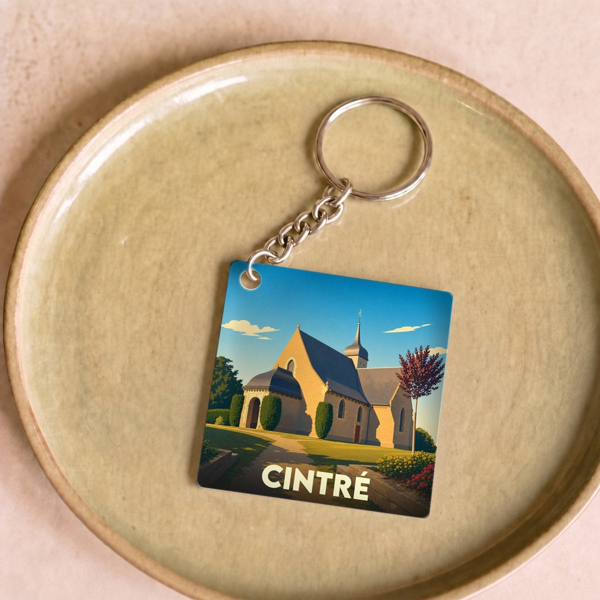 Porte-clés souvenir de la ville de Cintré avec une illustration stylisée de son église.