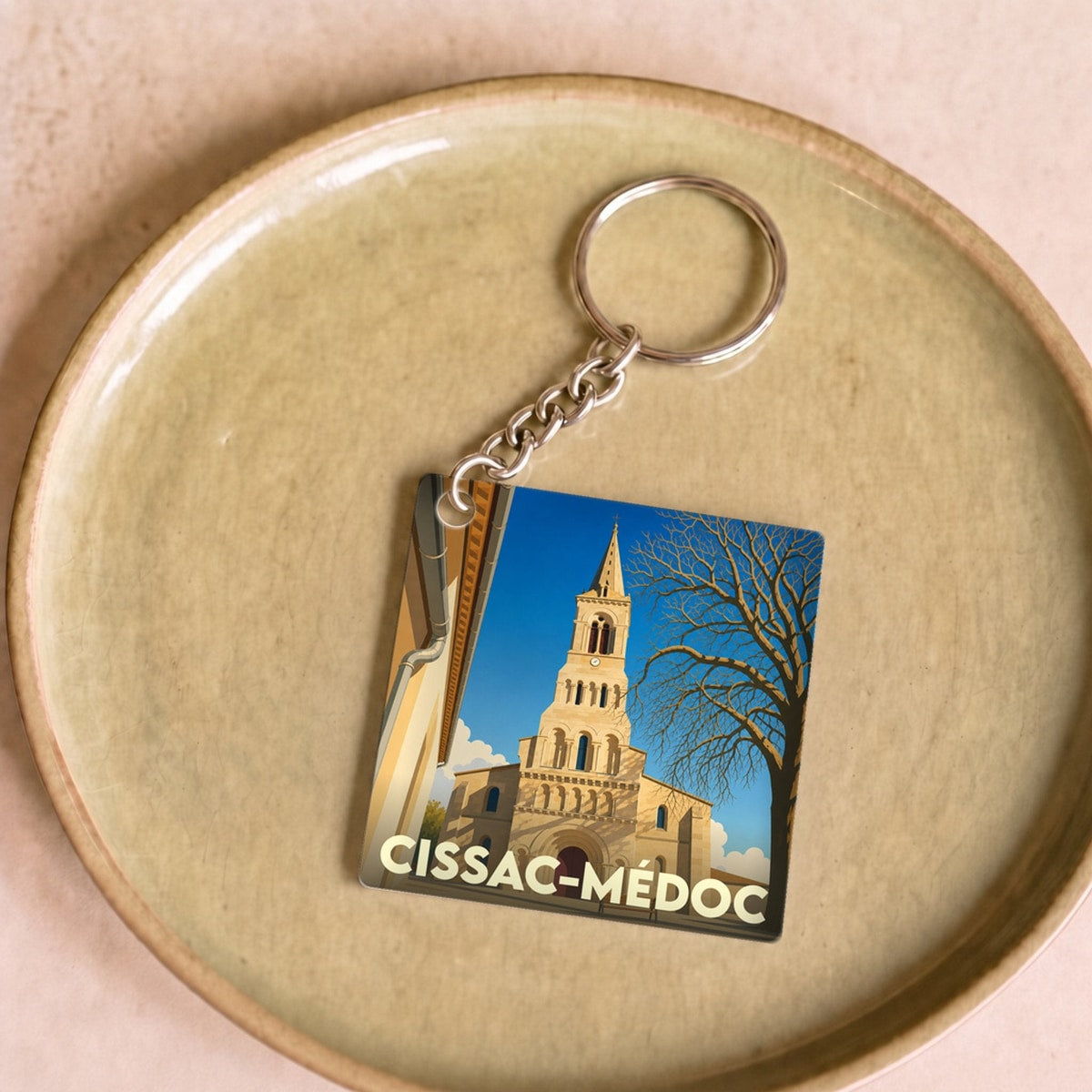 Porte-clés souvenir de la ville de Cissac-Médoc avec une illustration stylisée de son église.