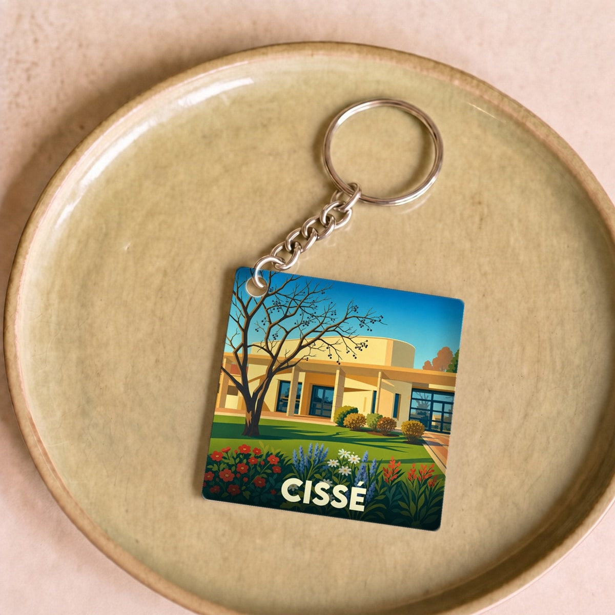 Porte-clés souvenir de la ville de Cissé avec une illustration stylisée de paysage urbain.