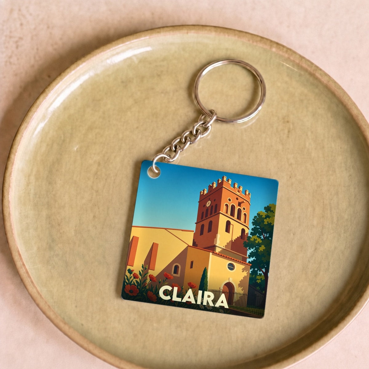 Porte-clés souvenir de la ville de Claira avec une illustration stylisée de son église.