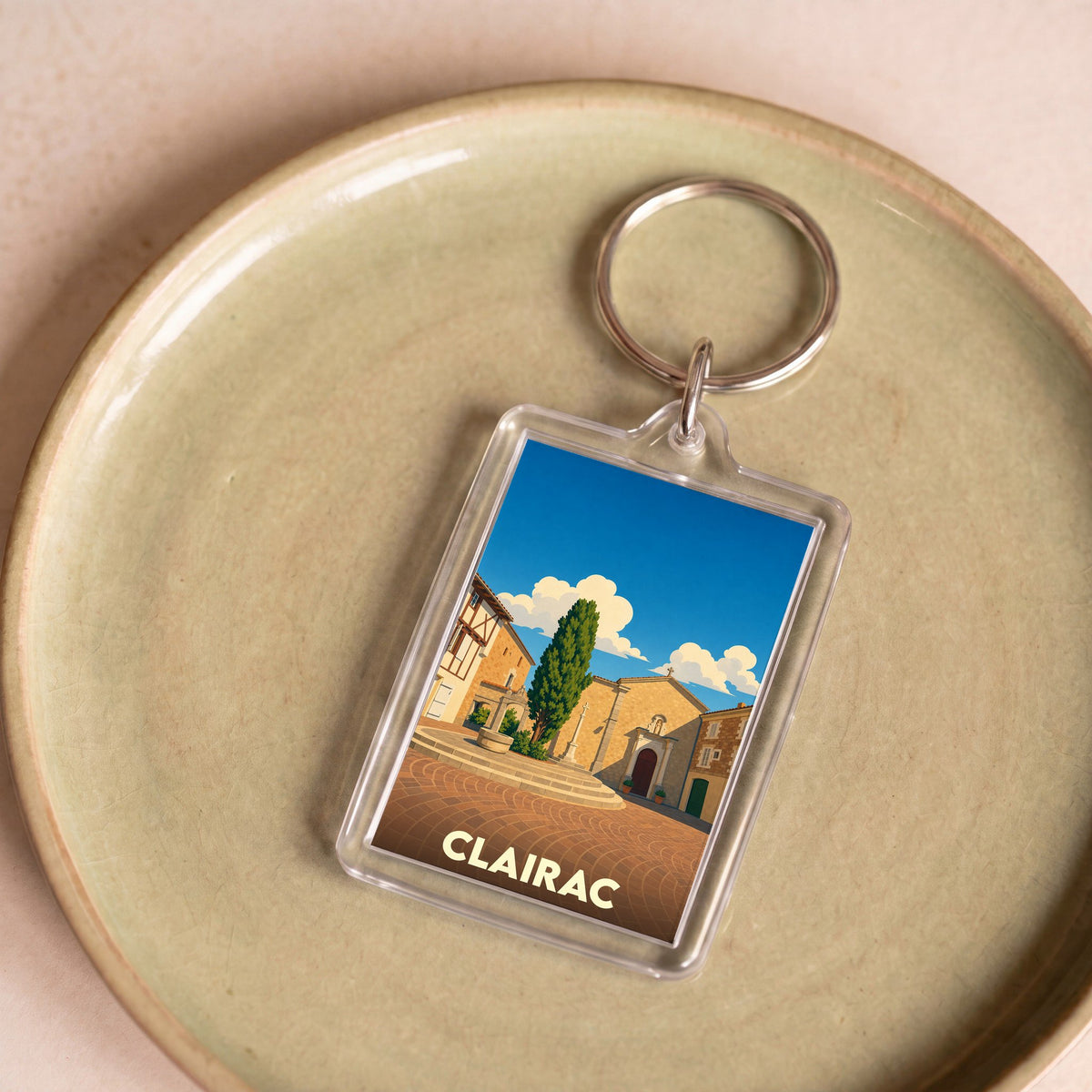 Porte-clés souvenir de la ville de Clairac avec une illustration stylisée.
