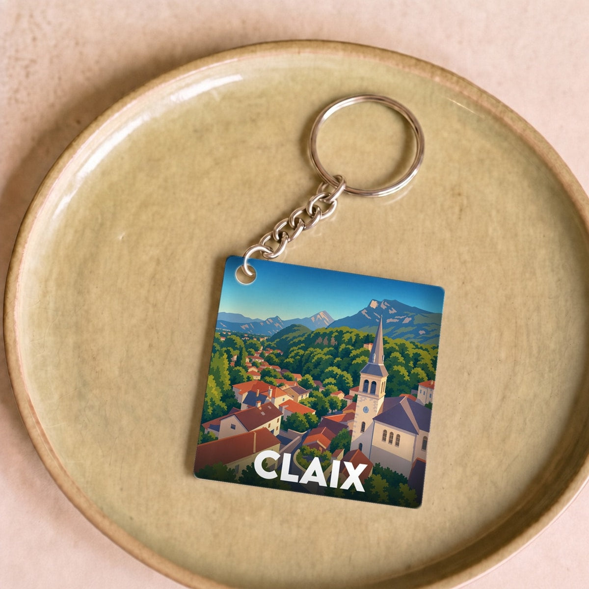 Porte-clés souvenir de la ville de Claix avec une illustration stylisée d'un paysage montagneux.