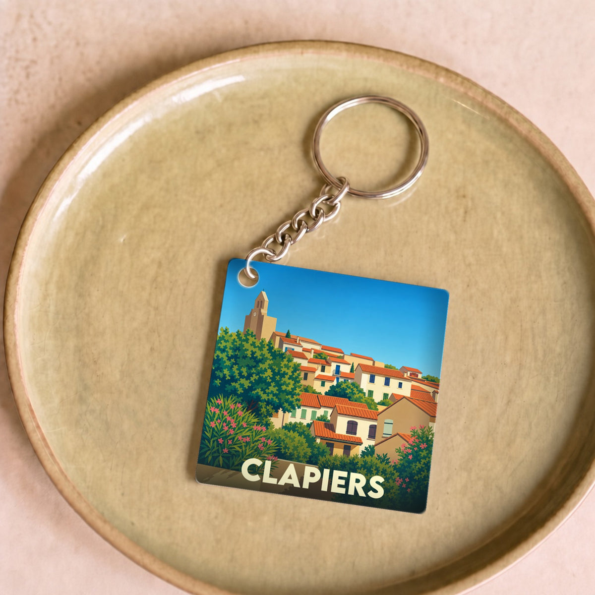 Porte-clés souvenir de la ville de Clapiers avec une illustration stylisée.