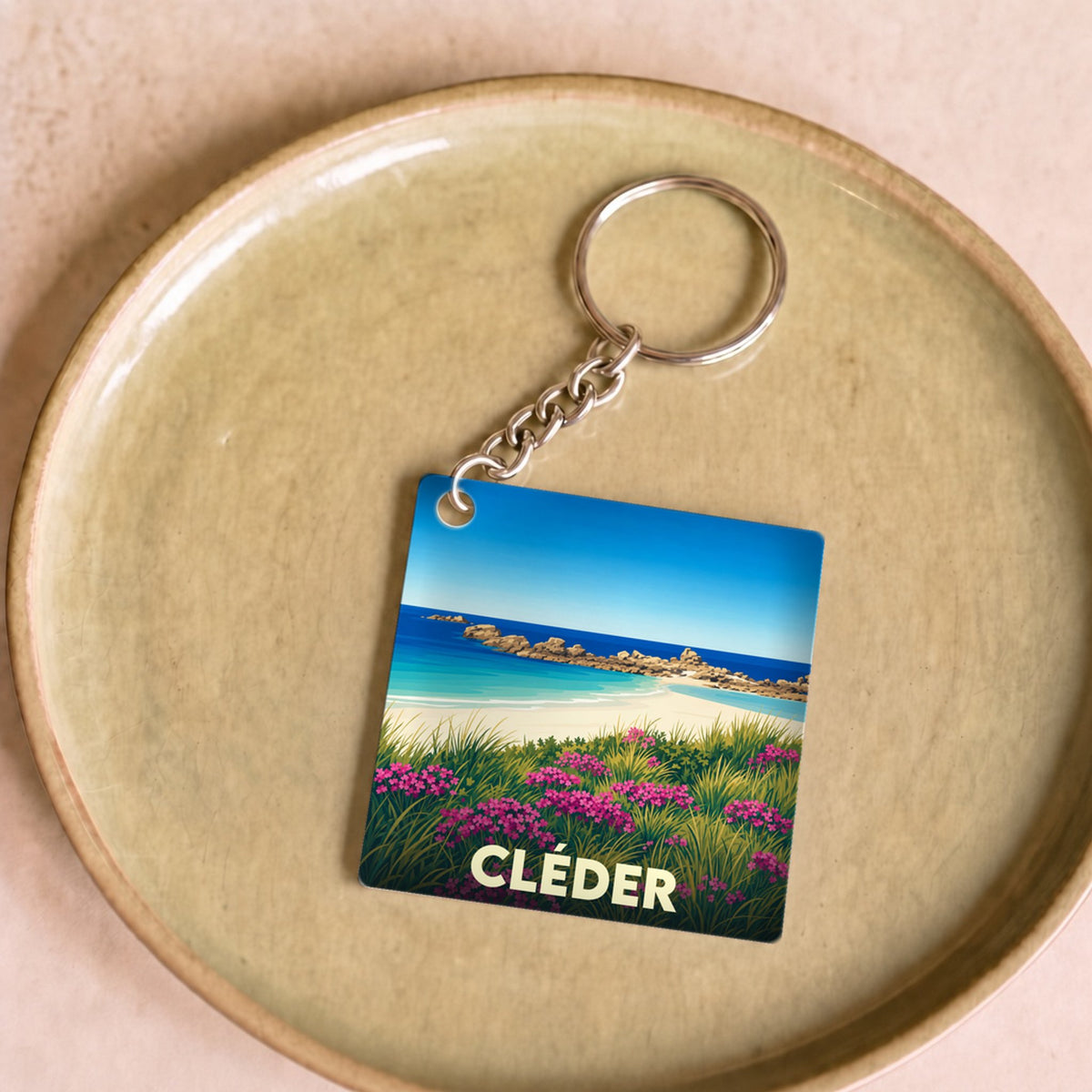 Porte-clés souvenir de la ville de Cléder avec une illustration stylisée de plage.