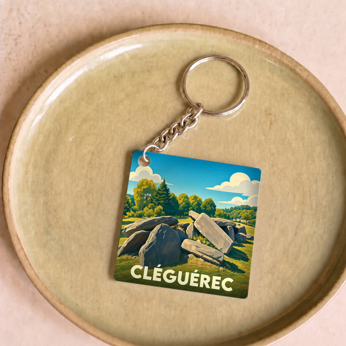 Porte-clés souvenir de la ville de Cléguérec avec une illustration stylisée de mégalithes.