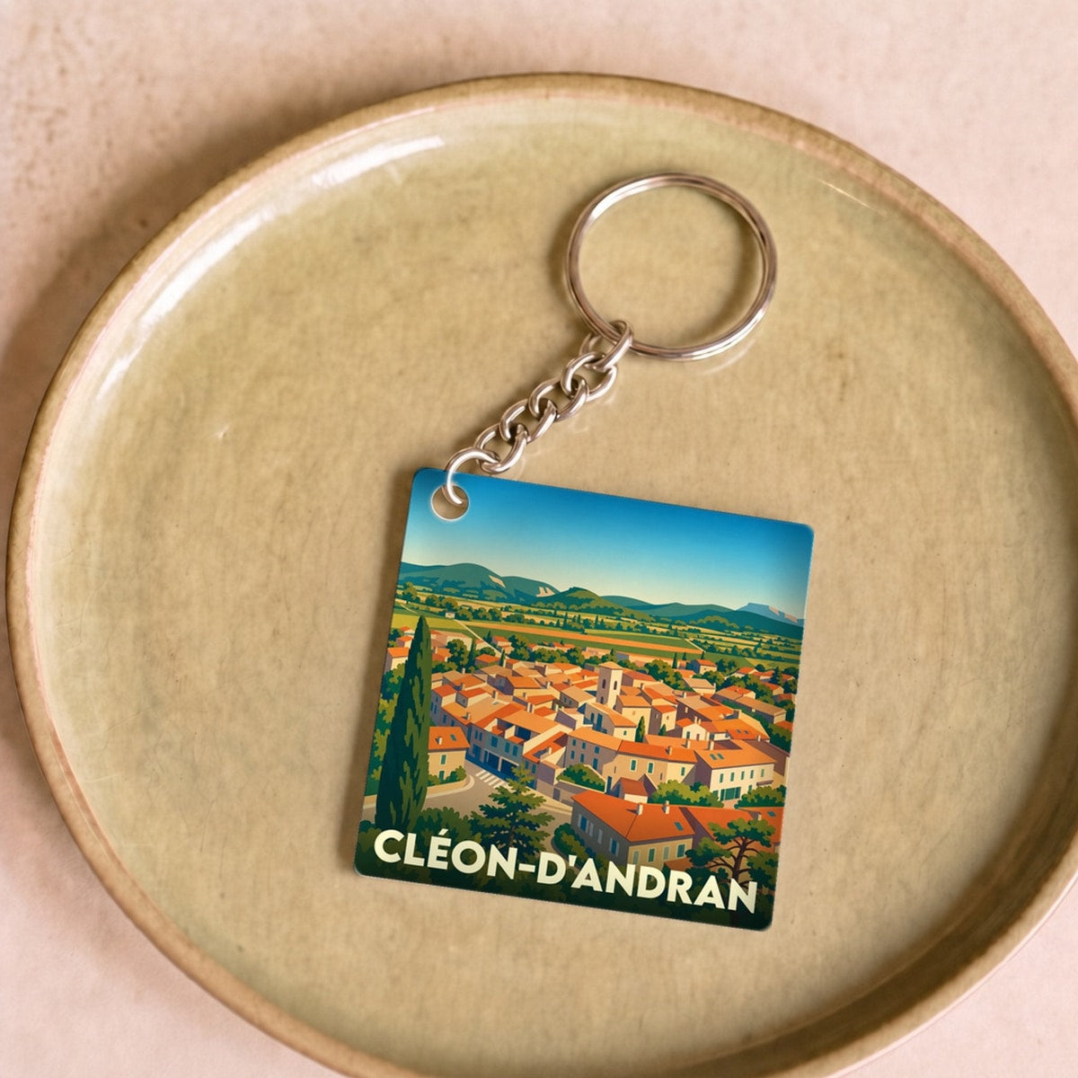 Porte-clés souvenir de la ville de Cléon-d'Andran avec une illustration stylisée.